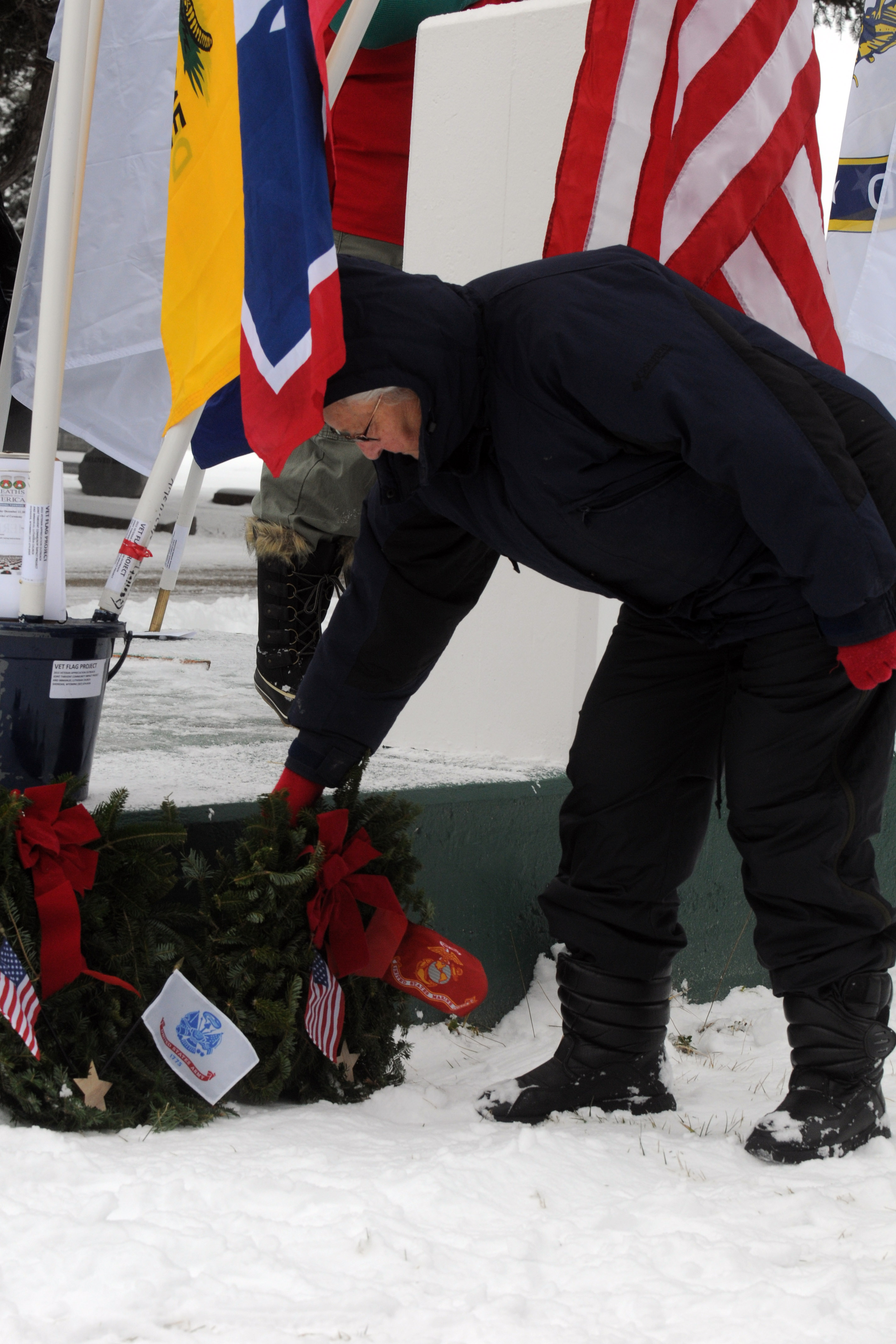 A member of the wreath committee places a U.S. Marine Corps' wreath on a cement platform during the ceremony. 