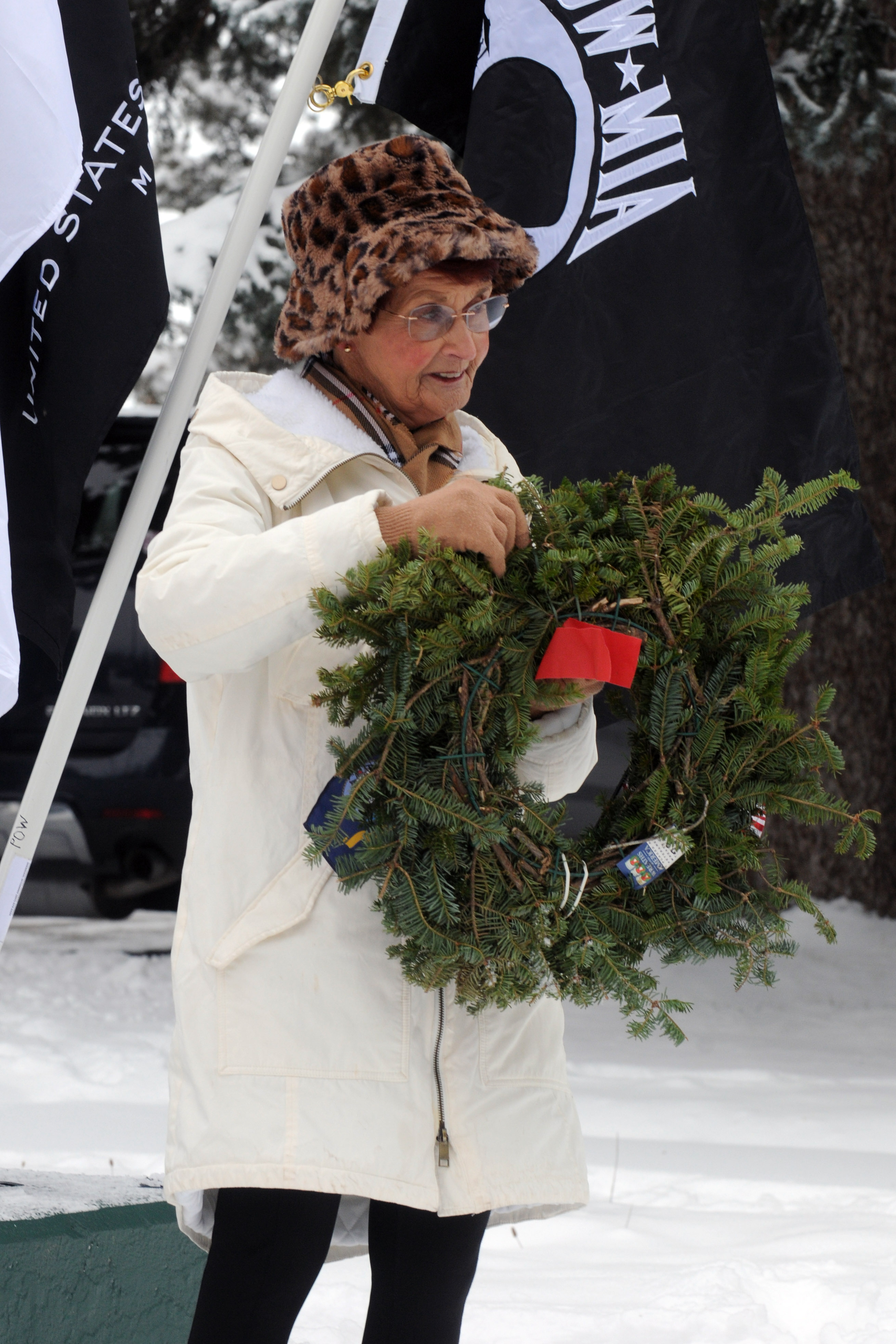 Judy Hayworth bows her head to recognize a sailor as she carries a wreath recognizing the U.S. Navy during the ceremony.