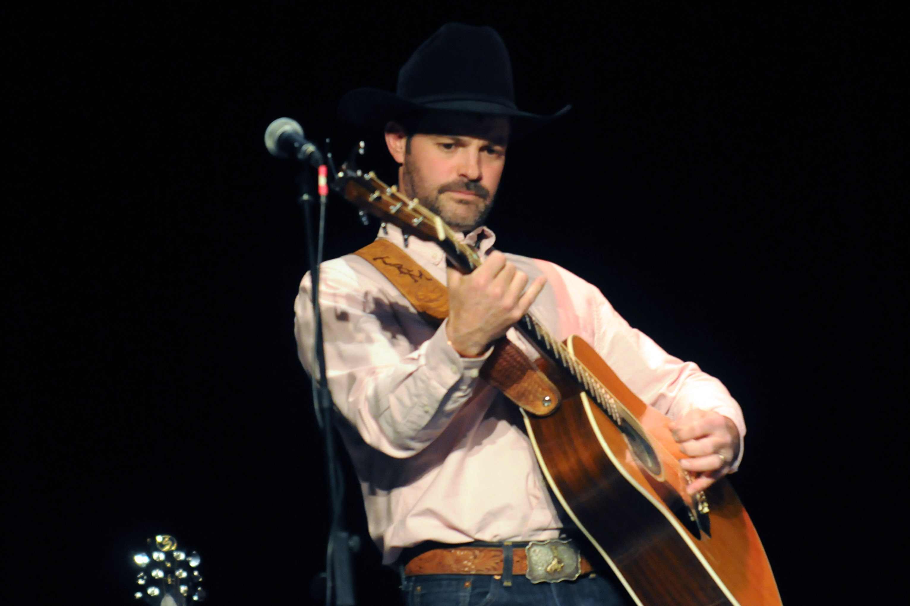 Tris Munsick strums his guitar.